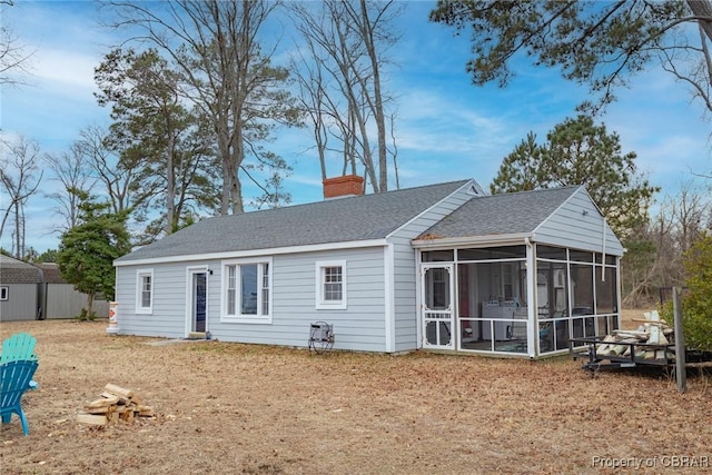 back of house with a sunroom and a yard