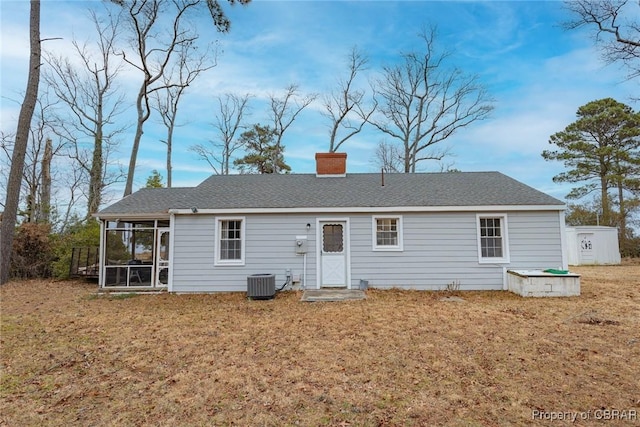 back of property featuring a sunroom, a lawn, and central AC