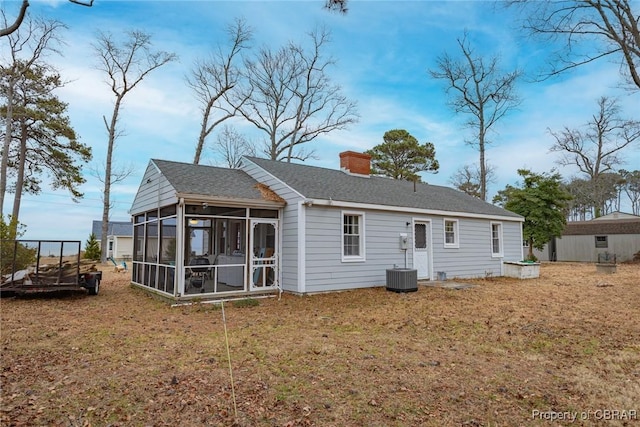 rear view of property featuring a sunroom and a yard