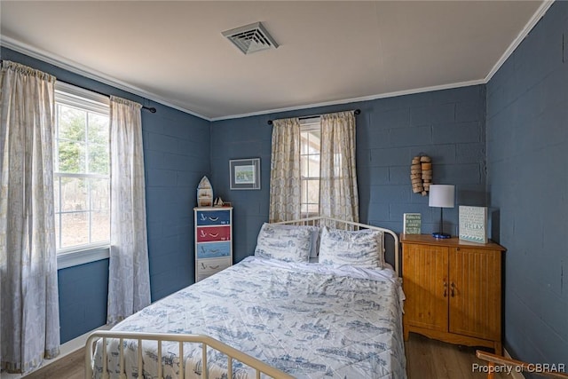 bedroom featuring hardwood / wood-style floors and crown molding