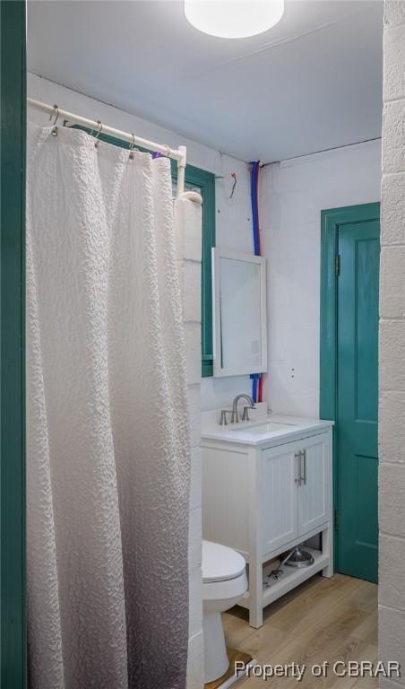 bathroom with curtained shower, hardwood / wood-style flooring, toilet, and vanity