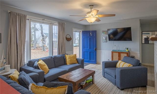 living room with light wood-type flooring and ceiling fan