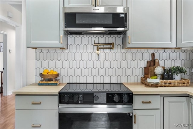 kitchen featuring black / electric stove and backsplash