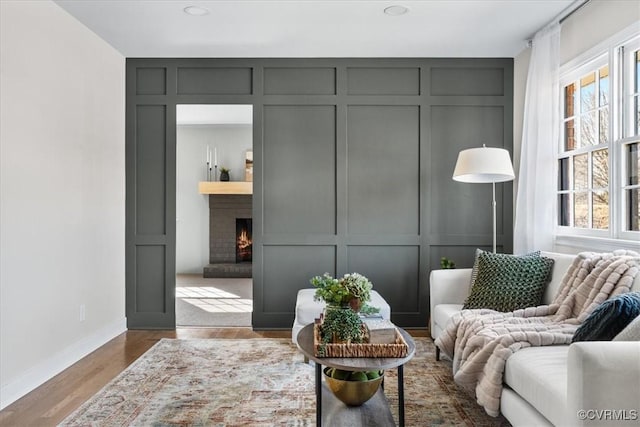 sitting room with a fireplace and light hardwood / wood-style floors