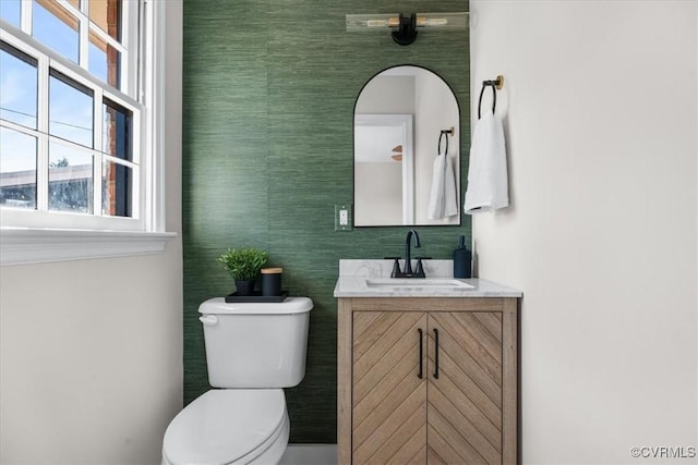 bathroom featuring vanity, a wealth of natural light, and toilet