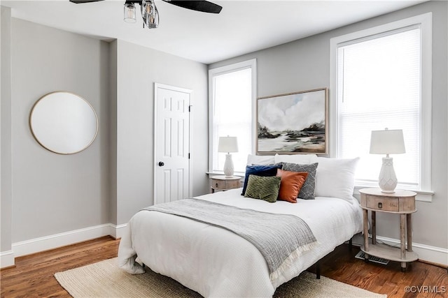 bedroom featuring hardwood / wood-style flooring, multiple windows, and ceiling fan