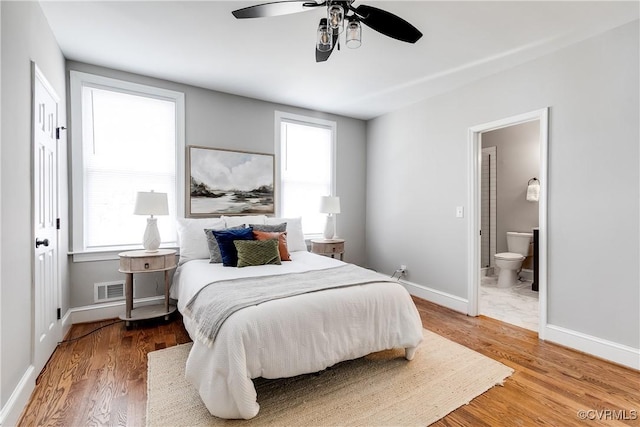 bedroom with hardwood / wood-style flooring, ensuite bathroom, and ceiling fan