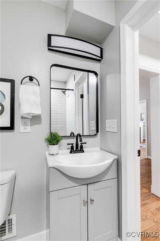 bathroom with vanity, toilet, walk in shower, and wood-type flooring