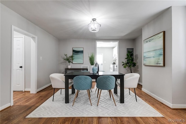 dining room with hardwood / wood-style floors and a notable chandelier