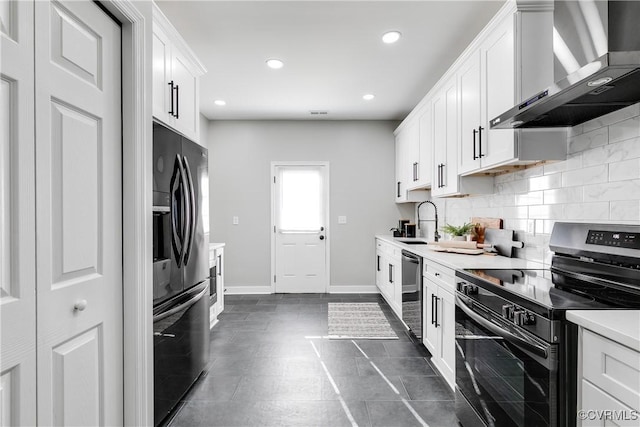 kitchen with sink, wall chimney range hood, white cabinets, and stainless steel appliances