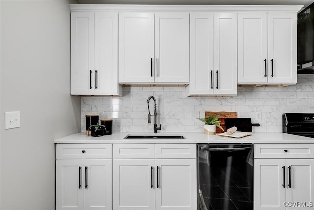 kitchen with decorative backsplash, sink, white cabinetry, and black dishwasher