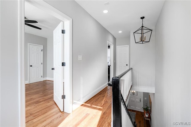 corridor featuring light hardwood / wood-style flooring and a notable chandelier