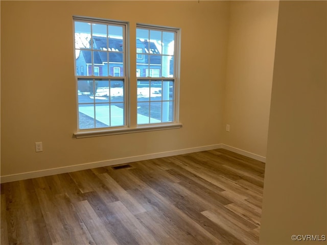 unfurnished room with hardwood / wood-style flooring and plenty of natural light