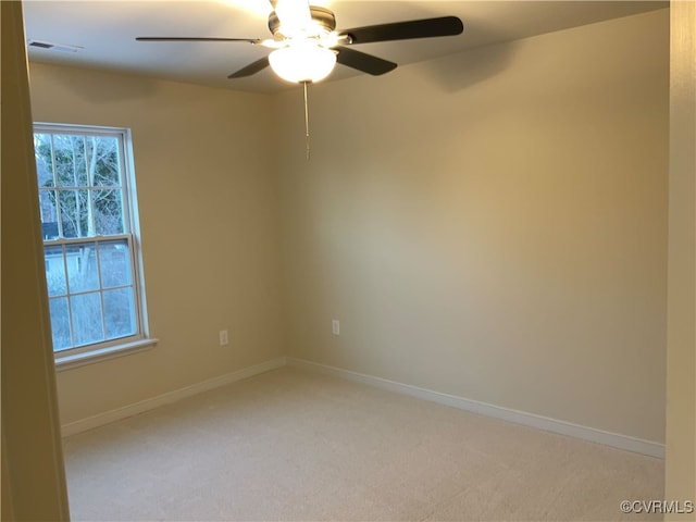 spare room featuring light carpet and ceiling fan