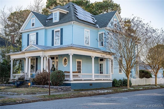 view of front of property with covered porch and solar panels