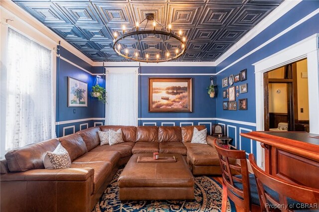 home theater room with ornamental molding and a chandelier