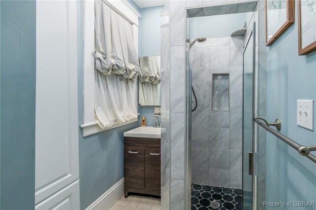 bathroom with a shower with shower door and vanity