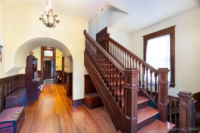 stairway featuring wood-type flooring and a chandelier