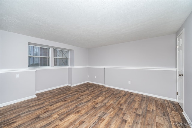 unfurnished room featuring dark hardwood / wood-style floors and a textured ceiling