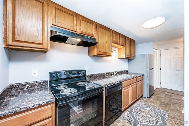 kitchen with sink, black appliances, and dark stone counters