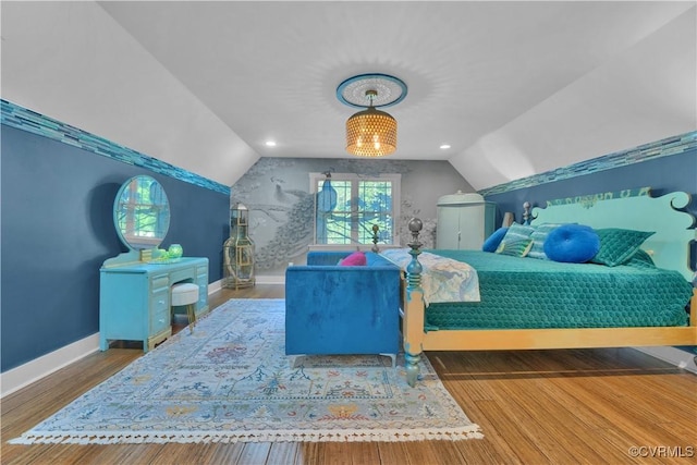 bedroom with lofted ceiling, wood finished floors, and baseboards