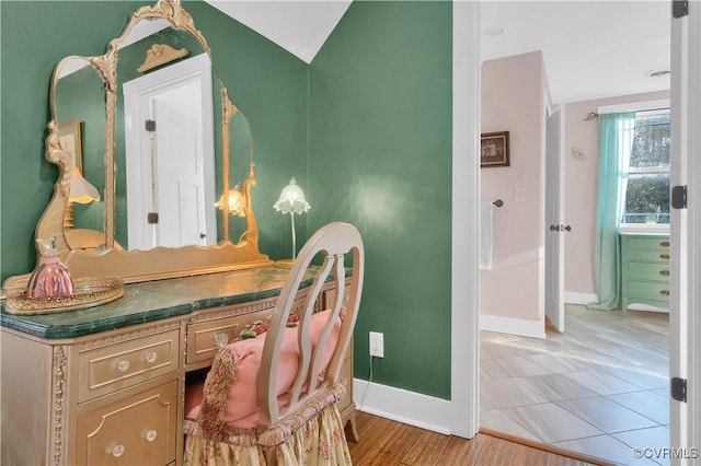 office area with vaulted ceiling, light wood-style flooring, and baseboards