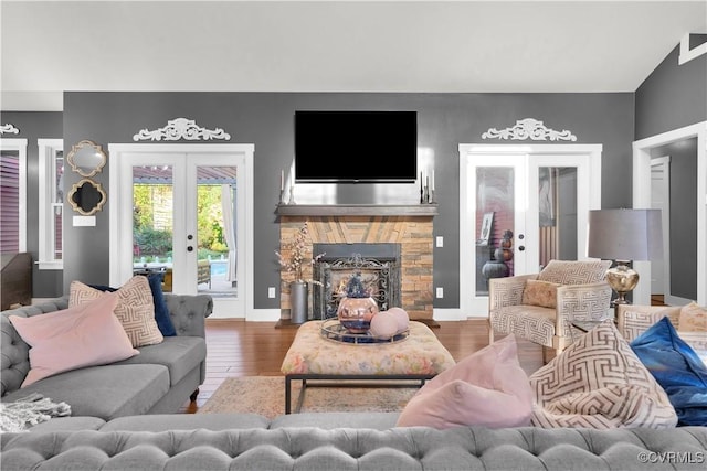 living area with french doors, a fireplace, and wood finished floors