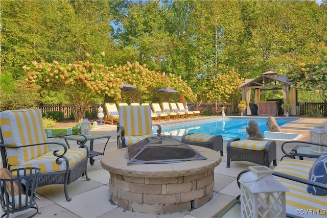 view of swimming pool with a fire pit, fence, a gazebo, a fenced in pool, and a patio area