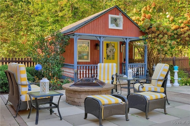 view of patio / terrace with a fire pit, an outdoor structure, and fence