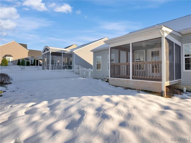 view of snow covered exterior featuring ceiling fan and a sunroom