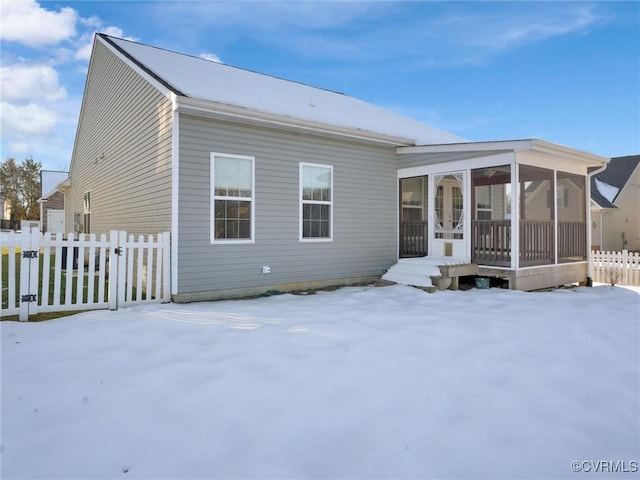 snow covered property with a sunroom