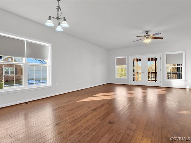 unfurnished living room with plenty of natural light, dark hardwood / wood-style floors, and french doors