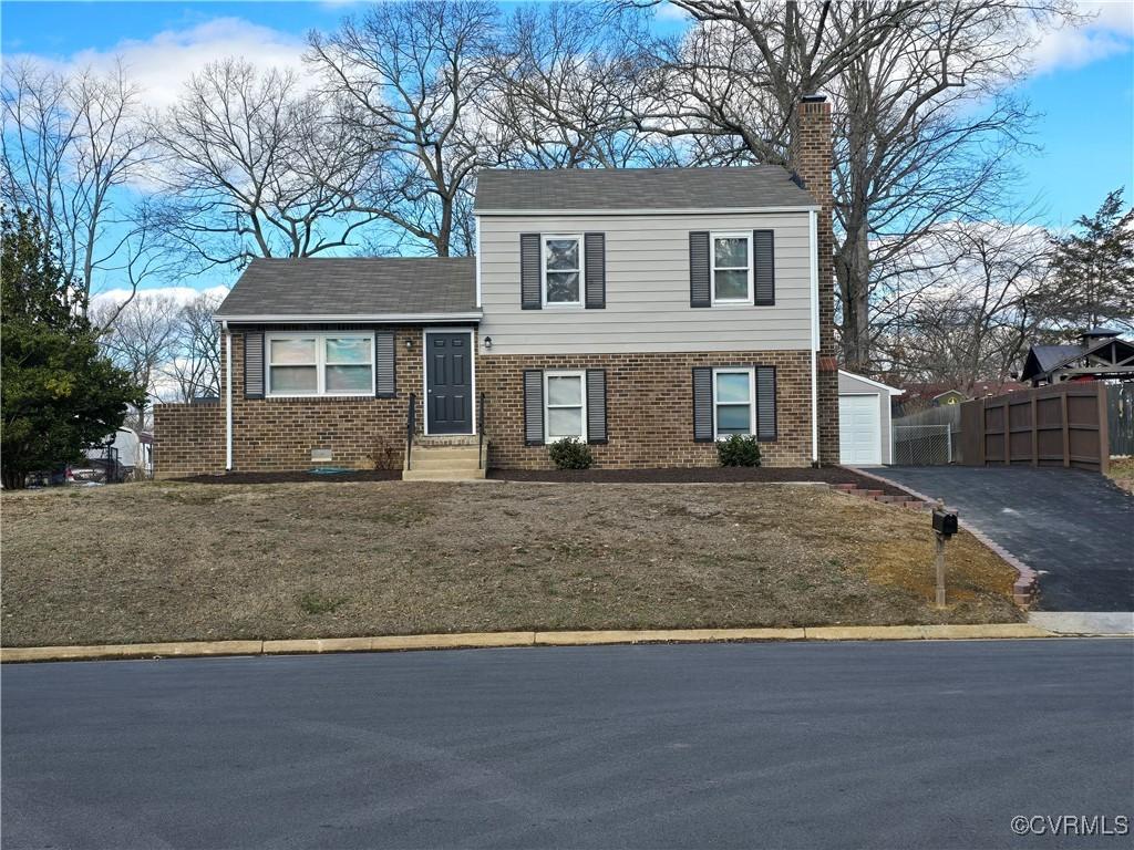 view of front facade with a front yard, an outbuilding, and a garage