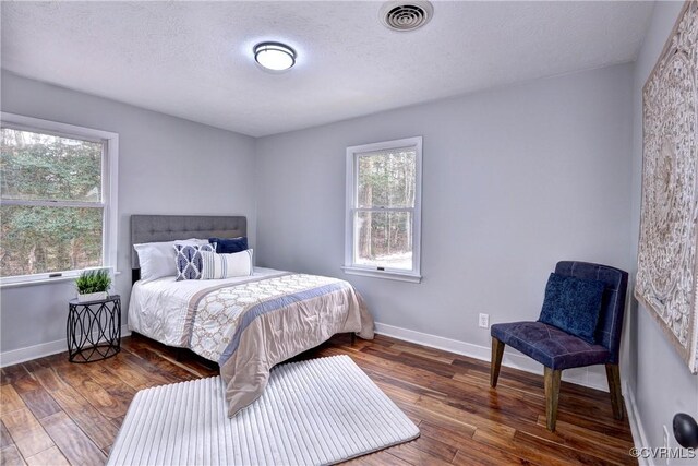 bedroom featuring dark hardwood / wood-style floors and a textured ceiling