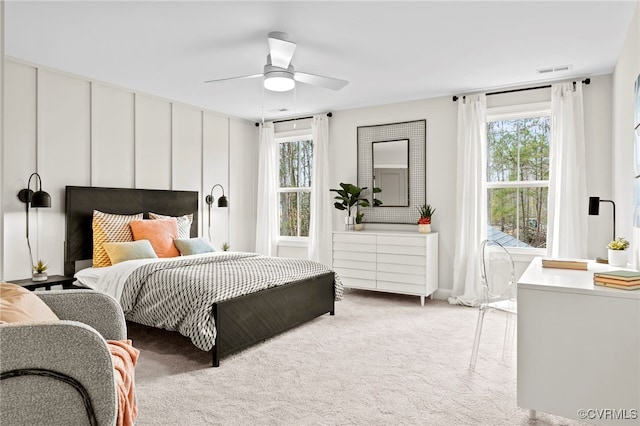 carpeted bedroom with multiple windows and ceiling fan