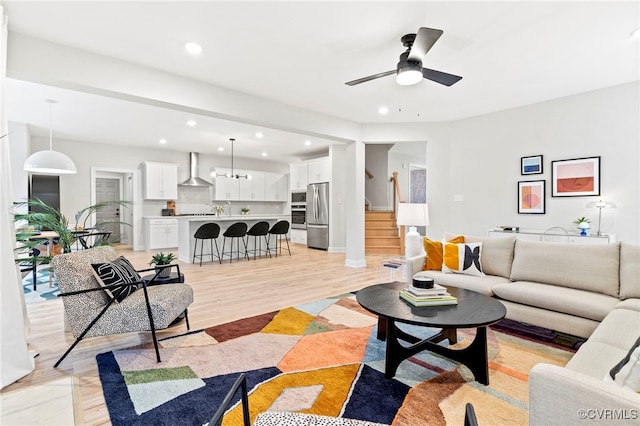 living room with ceiling fan and light wood-type flooring