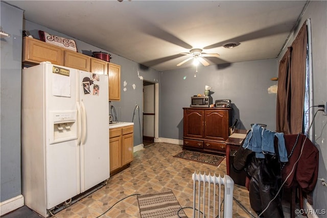 kitchen with ceiling fan, white fridge with ice dispenser, and light brown cabinetry