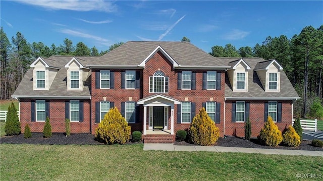 colonial-style house featuring a front yard