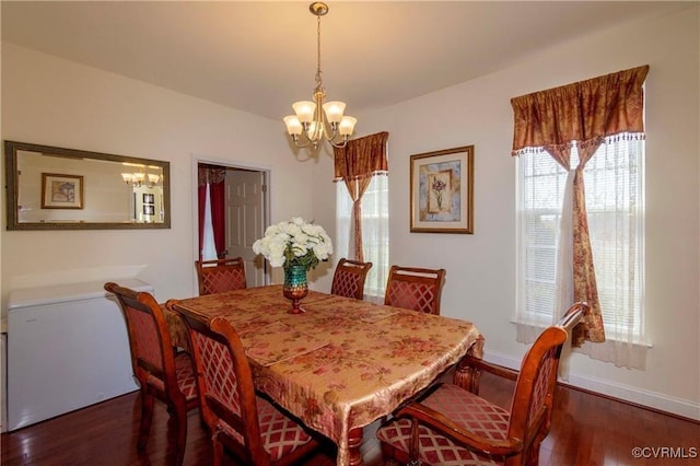 dining area with dark wood-type flooring and a chandelier