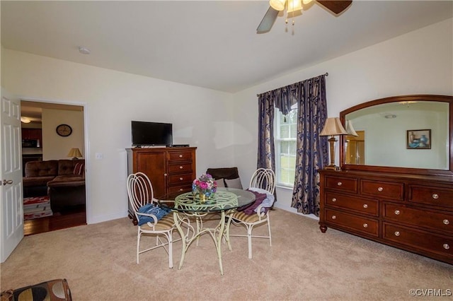 carpeted dining area featuring ceiling fan