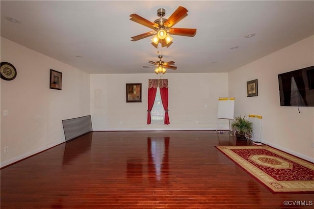 interior space with dark wood-type flooring and ceiling fan