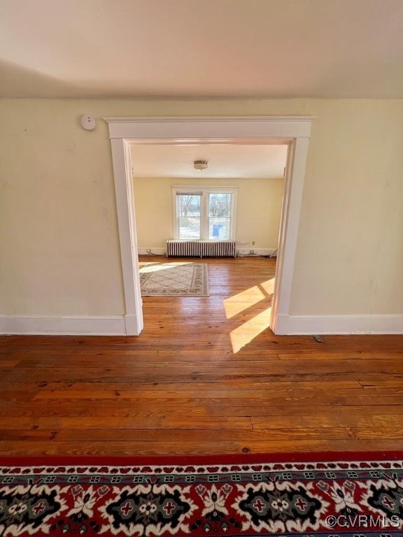 hall featuring radiator and hardwood / wood-style floors