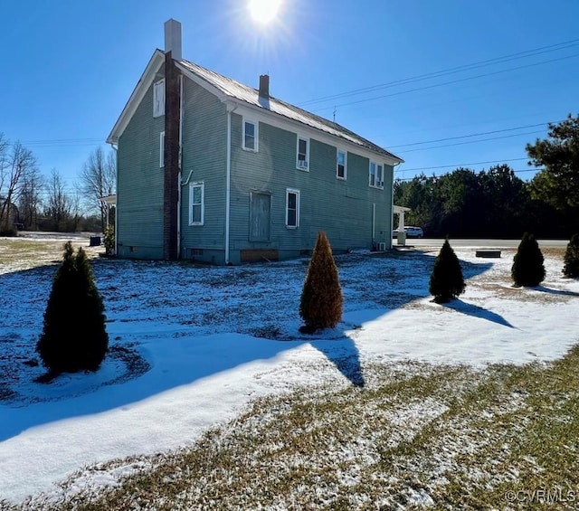 view of snow covered rear of property