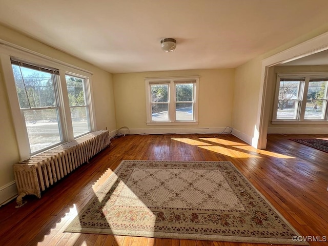 empty room with hardwood / wood-style flooring and radiator