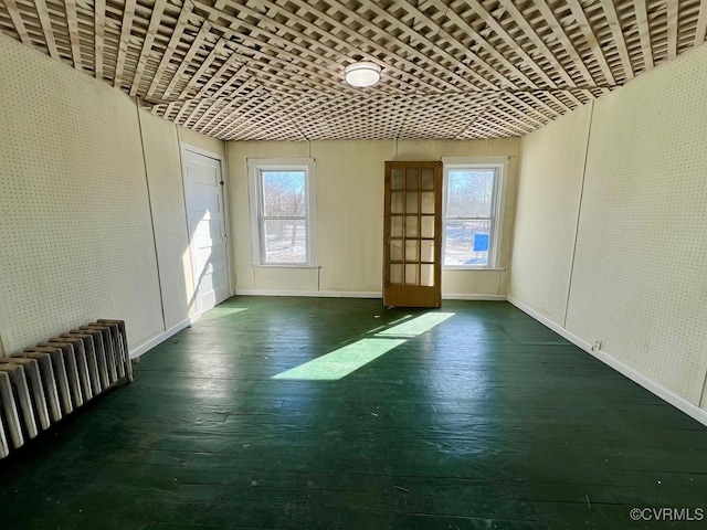 empty room with radiator and dark wood-type flooring