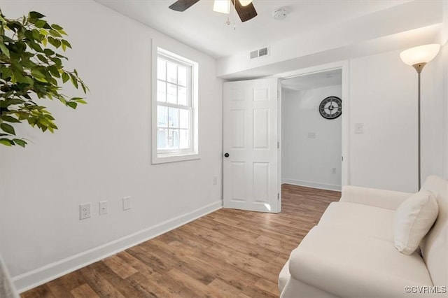 sitting room with wood-type flooring and ceiling fan