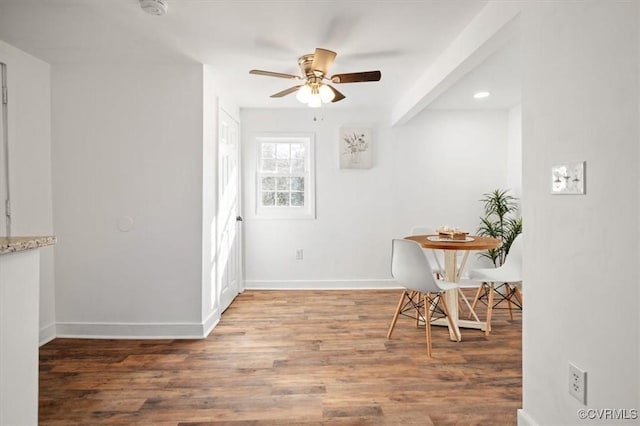 dining room with hardwood / wood-style flooring, beamed ceiling, and ceiling fan