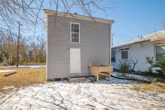 view of snow covered back of property