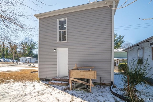 view of snow covered rear of property