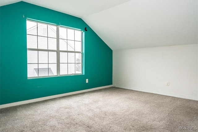 additional living space with vaulted ceiling and carpet floors